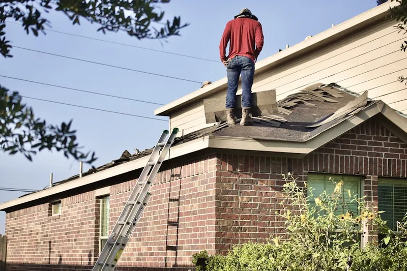 Professional roofer working on a residential roof in Occum